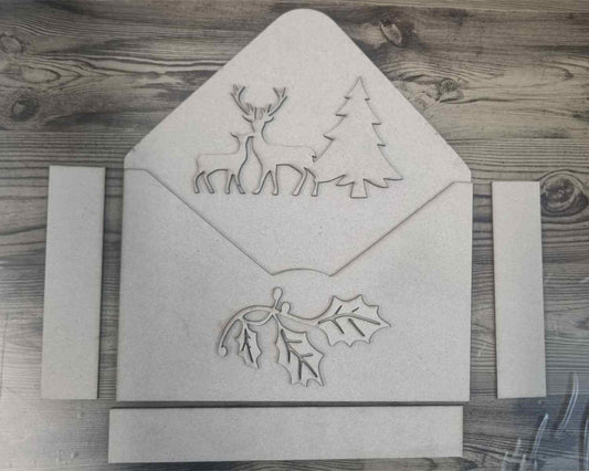 3Quarter Designs Christmas Envelope Box chipboard pieces laid flat showing envelope panels and deer, tree and holly decor
