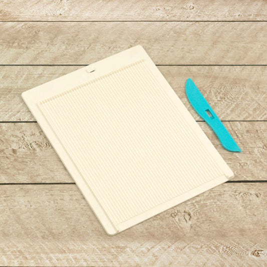 Mini Scoring Board and blue bone folder tool on a wooden backdrop.