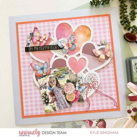 Scrapbook layout using Uniquely Creative Oh So Lovely collection featuring a heart cluster overlay, butterflies, gingham paper and Oh My Happy Heart sentiment with a child's photo by Kylie Kingham