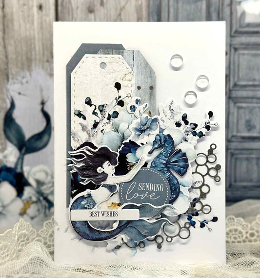 Handmade card in blue tones with a mermaid and seahorse and background tags made with the Paper Tag Die by Uniquely Creative