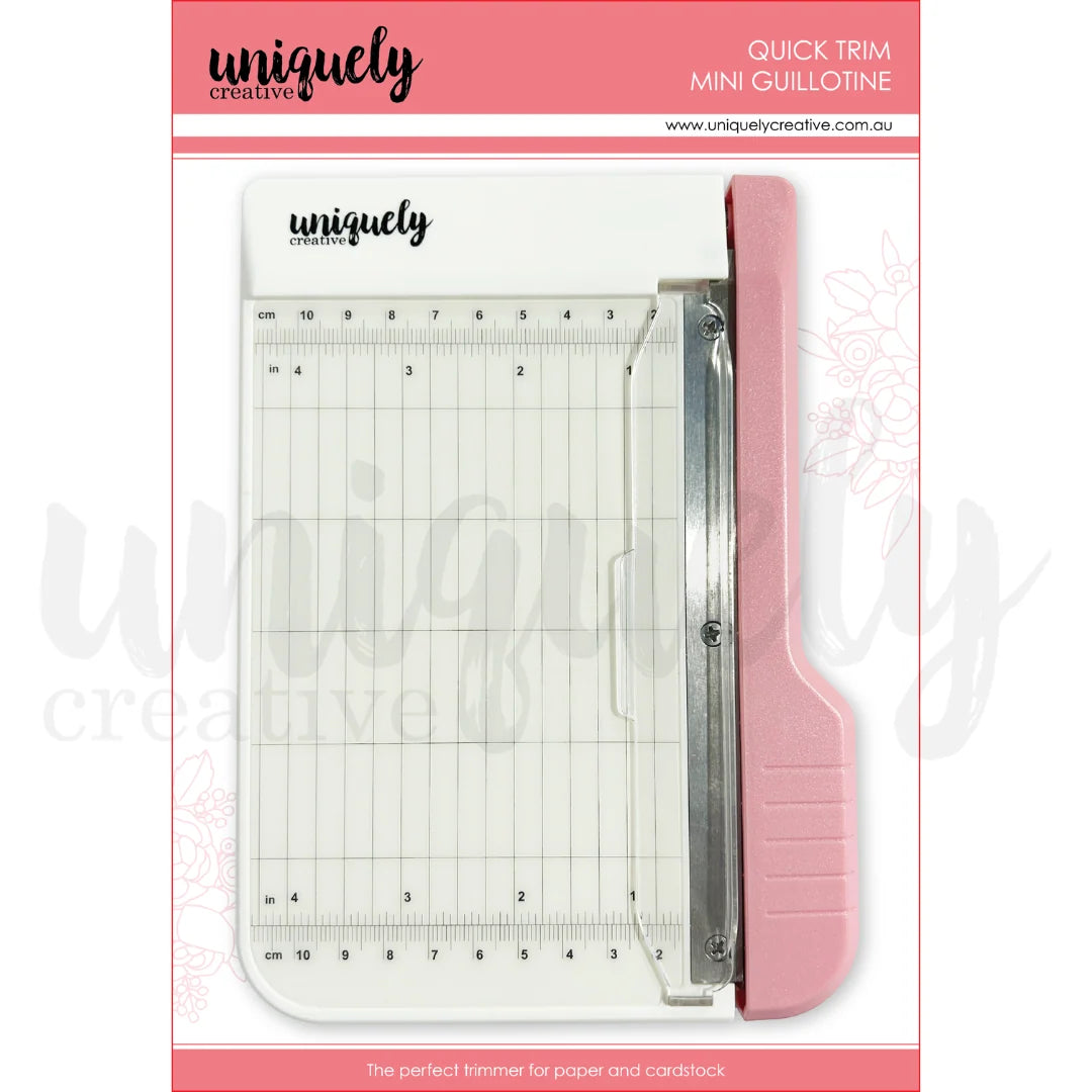 Uniquely Creative Quick Trim Mini Guillotine paper trimmer with pink handle and metric and imperial measurement grid
