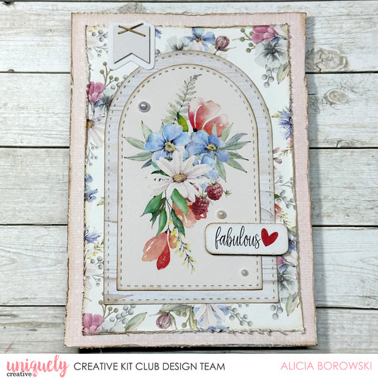Sample card using Uniquely Creative Stitched Arches Die with layered white arches framing watercolour floral bouquet and fabulous sentiment on distressed pink floral background