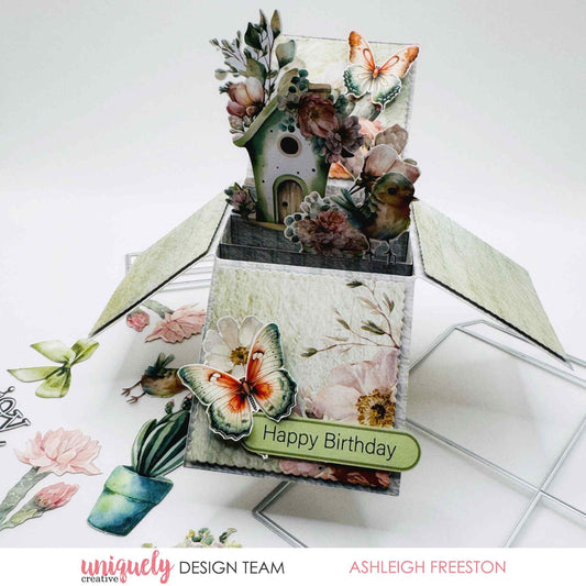 Tea and Tranquility box card by Uniquely Creative design team — pop-up box card featuring a birdhouse scene with botanical clusters, butterfly and bird die-cuts, and a "Happy Birthday" sentiment in soft sage and blush