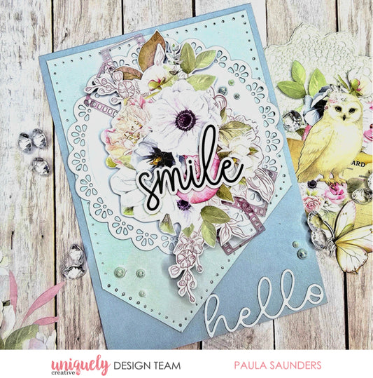 Handmade greeting card using Whispers of Wisdom papers featuring white anemone florals, smile sentiment die cut, decorative doily, and butterfly embellishments on light blue cardstock with pearl accents