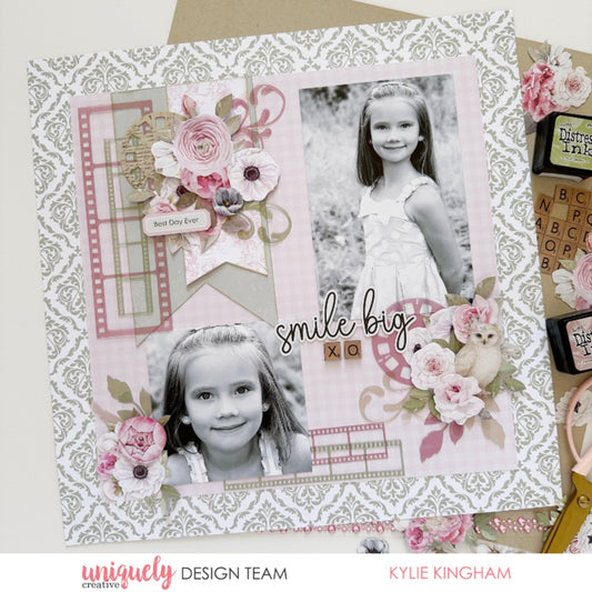 12x12 scrapbook layout using Uniquely Creative Whispers of Wisdom collection featuring black and white children's photos with smile big sentiment die cut, watercolour florals in blush pink, pink gingham plaid papers, sage green damask pattern, and decorative owl embellishments