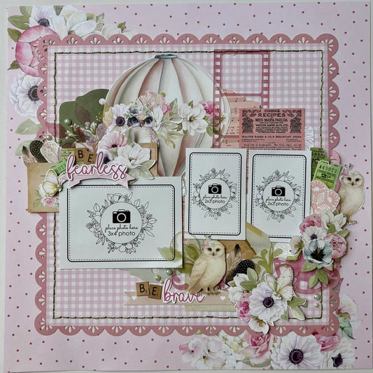 Whispers of Wisdom scrapbook layout featuring pink gingham background, die-cut scalloped borders, watercolour hot air balloon and anemone florals, three photo mats with floral wreaths, vintage ephemera, owl embellishments, and Be Fearless Be Brave sentiments
