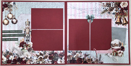 A double-sided scrapbook layout class sample featuring a festive Christmas theme with four dark red photo frames, surrounded by holiday decorations including pinecones, ornaments, a nutcracker, bells, and a silver ornament on a textured light blue and white background.