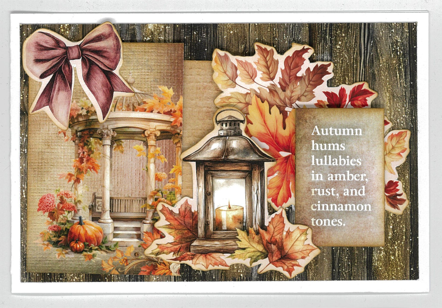 Autumn Whispers card sample 2 – landscape card with dark timber background, mauve bow, gazebo, glowing lantern and autumn leaves die-cut embellishments with quote 'Autumn hums lullabies in amber, rust, and cinnamon tones'