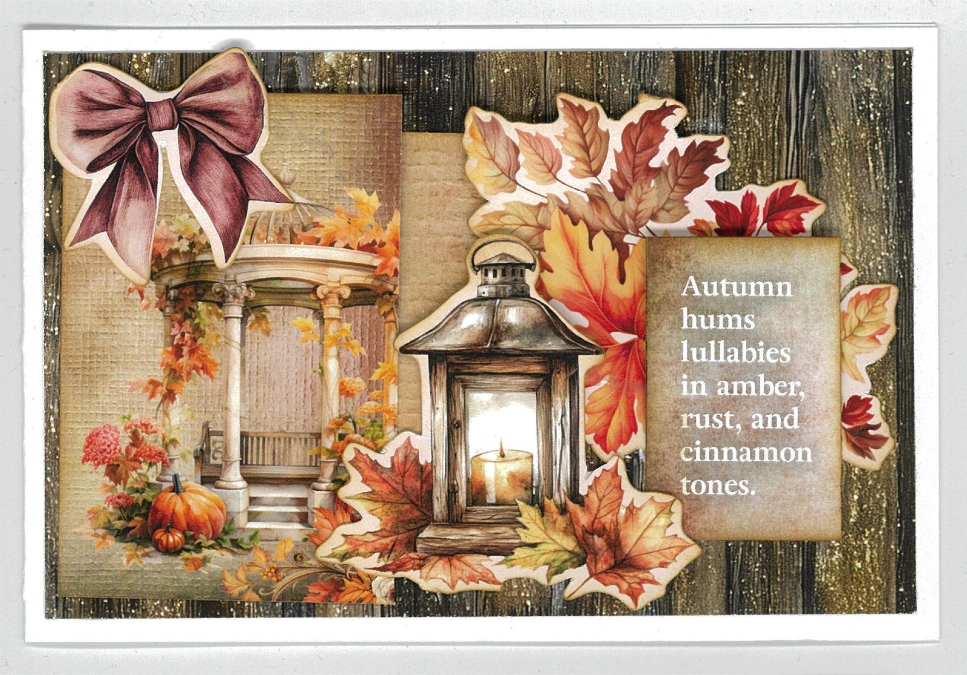 Autumn Whispers card sample 2 – landscape card with dark timber background, mauve bow, gazebo, glowing lantern and autumn leaves die-cut embellishments with quote 'Autumn hums lullabies in amber, rust, and cinnamon tones'