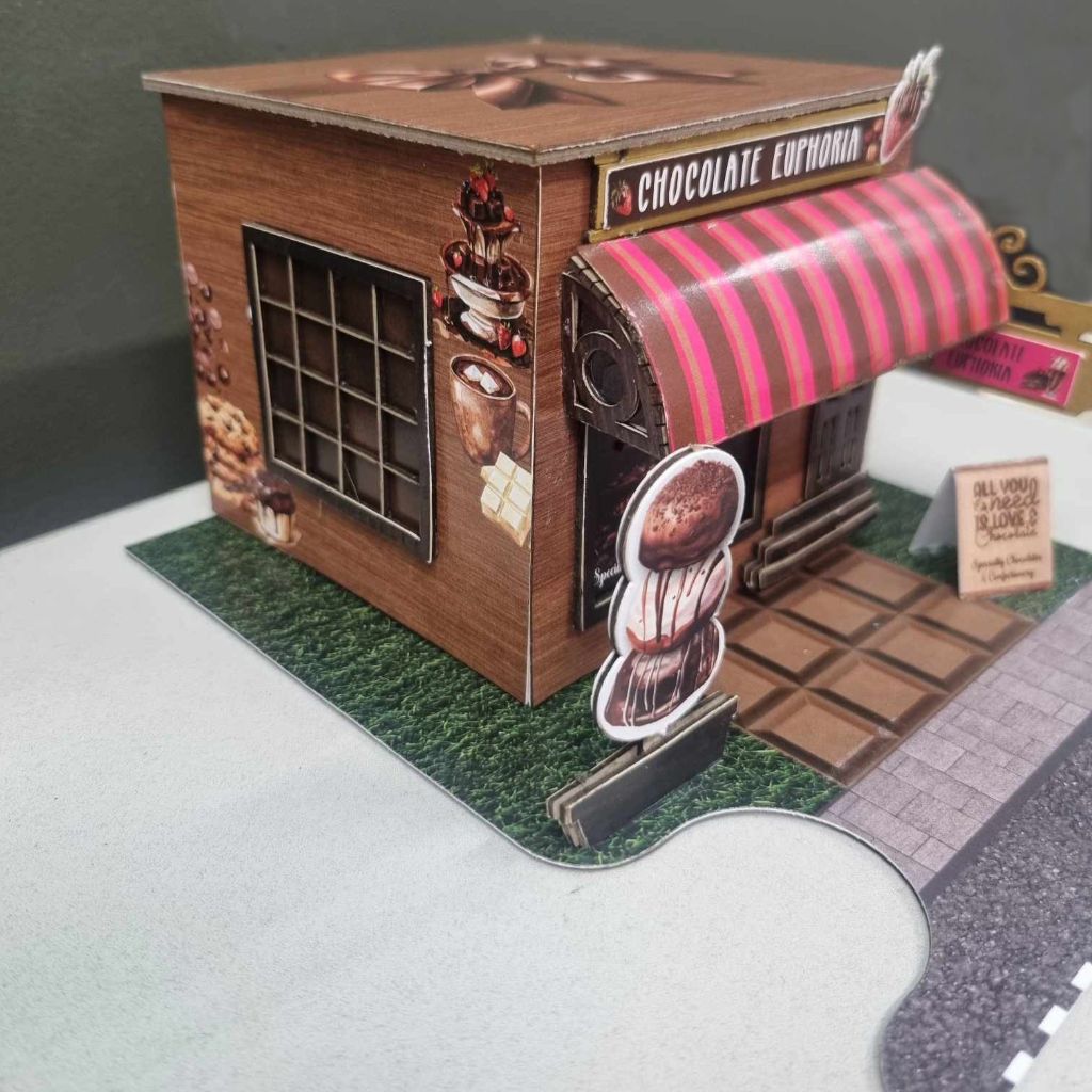 Close-up of the Chocolate Euphoria shop facade showing the Specialty Chocolates and Confectionery display window and strawberry embellishment