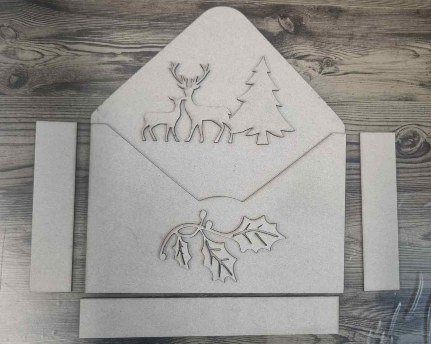 3Quarter Designs Christmas Envelope Box chipboard pieces laid flat showing envelope panels and deer, tree and holly decor