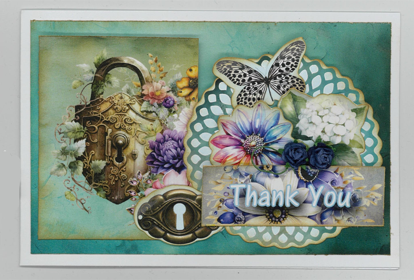Handmade Thank You card using Floral Mechanica 6x4 Card Making Kit by 3Quarter Designs — landscape card featuring ornate steampunk heart padlock, keyhole, teal doily die-cut, black and white butterfly, and layered purple, blue, and pink florals on a teal distressed background 
