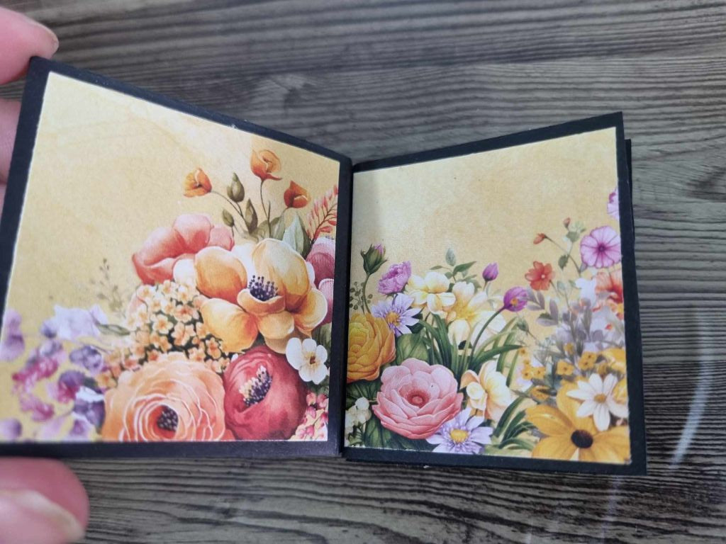 Mini album open to a spread — pink and orange floral bouquet on the left, wildflower meadow on the right