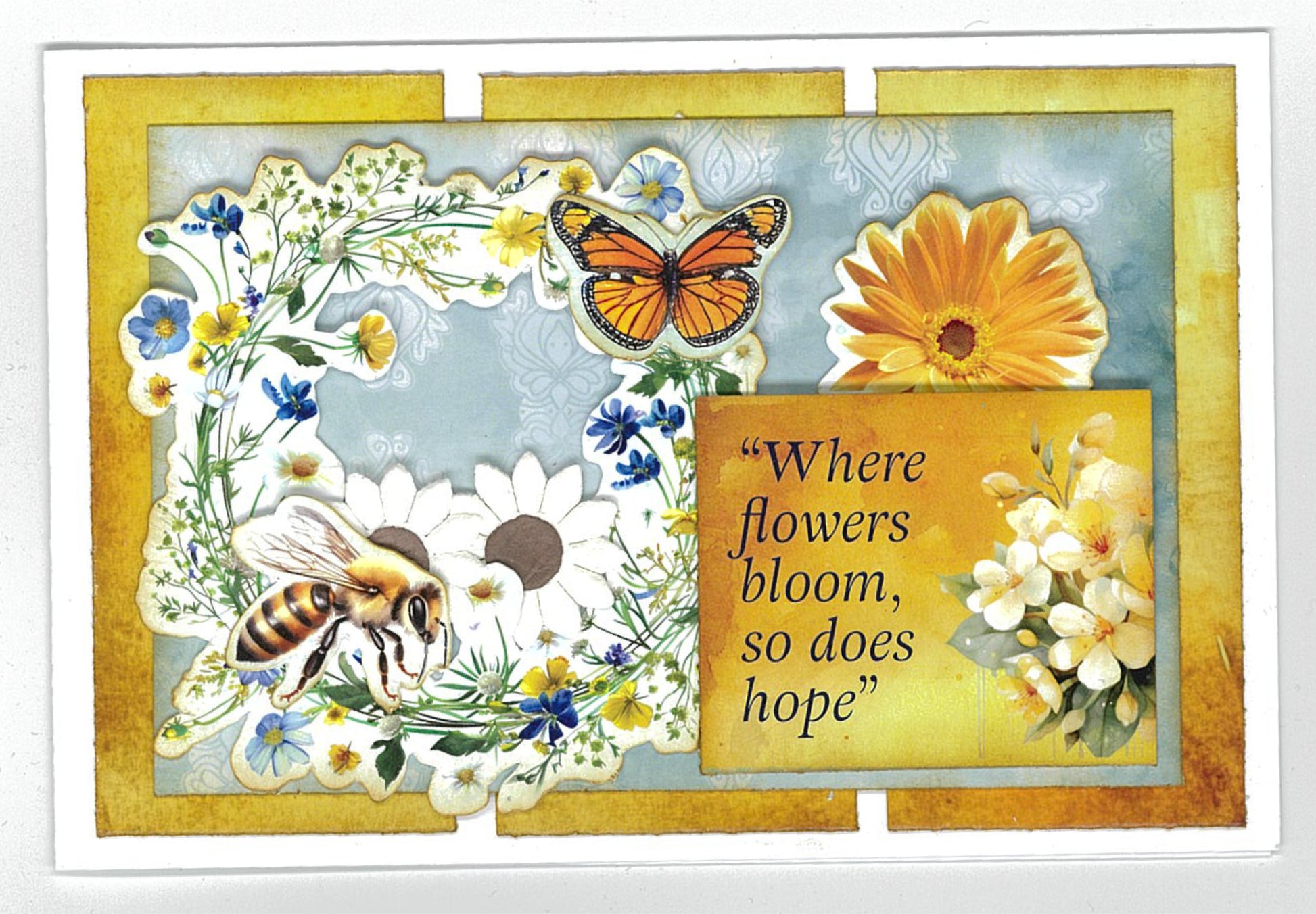 Finished card sample from Honey Fields kit featuring floral wreath with bee, butterfly, gerbera and Where flowers bloom so does hope sentiment on golden watercolour background 