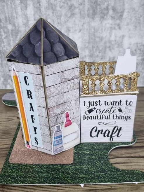 3Quarter Designs Imagine If Craft Store miniature building right side view showing CRAFTS lettering with pencil die-cut, crackle white wood panel walls, paint tube die-cuts, I Just Want to Create Beautiful Things Craft sign, gold glitter balustrade, and grass jigsaw base board