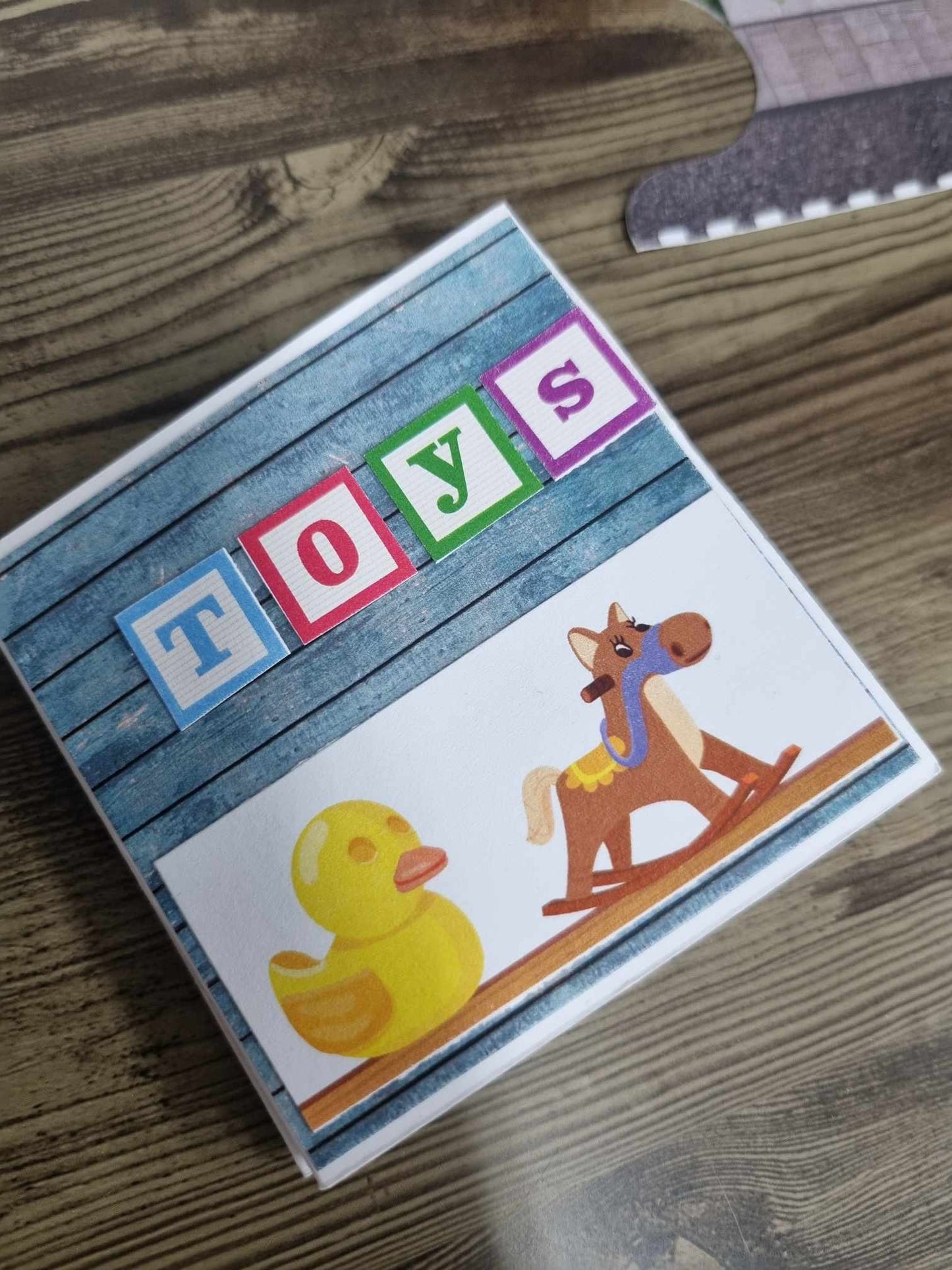 3Quarter Designs Little Wonders Toy Emporium mini album cover featuring TOYS alphabet block letters, yellow rubber duck, and rocking horse die-cuts on a blue timber-look panel