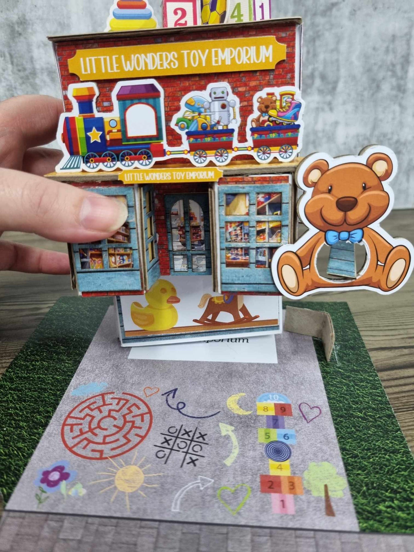 3Quarter Designs Little Wonders Toy Emporium showing shop being lifted up to reveal mini album inside. 