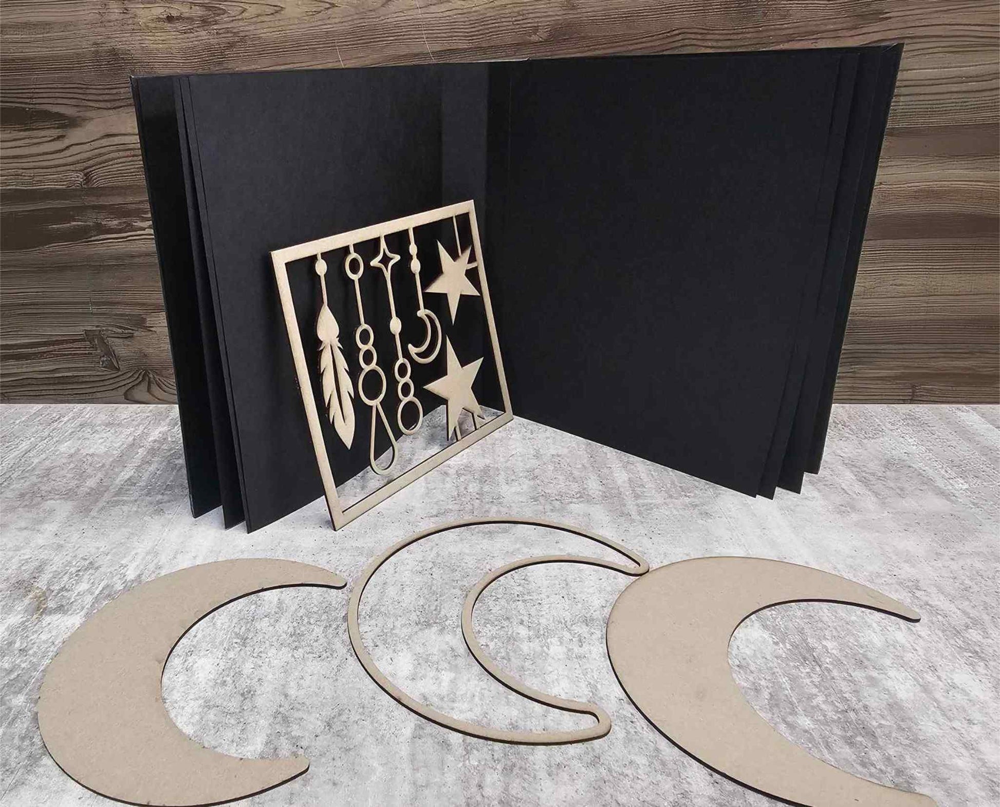 3Quarter Designs Moon Album Base Kit showing open black chipboard album with three crescent moon chipboard pieces and dangles and stars design