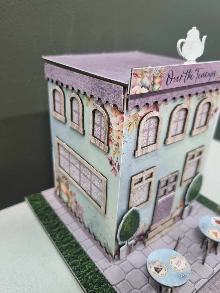 Close-up of the Over the Teacups Café showing arched windows, teapot on the roof, and floral details
