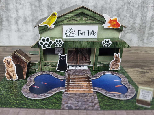 3Quarter Designs Pet Tails Pet Shop fully assembled front view showing the Pet Tails sign, paw print die-cuts, die-cut animals, and bone-shaped pond with timber bridge