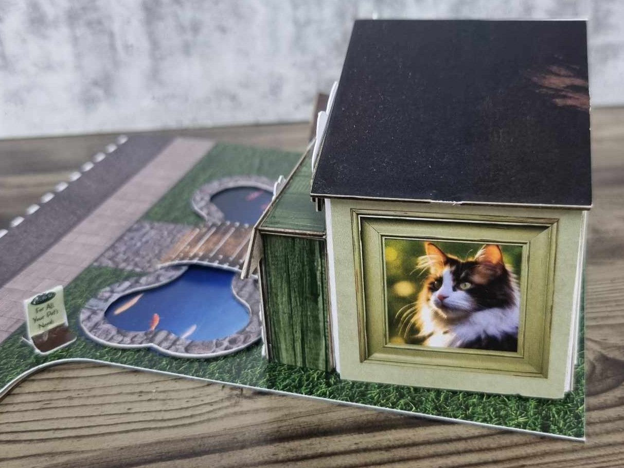 3Quarter Designs Pet Tails Pet Shop side view showing the photo frame window with a black cat illustration on the sage green timber-grain wall