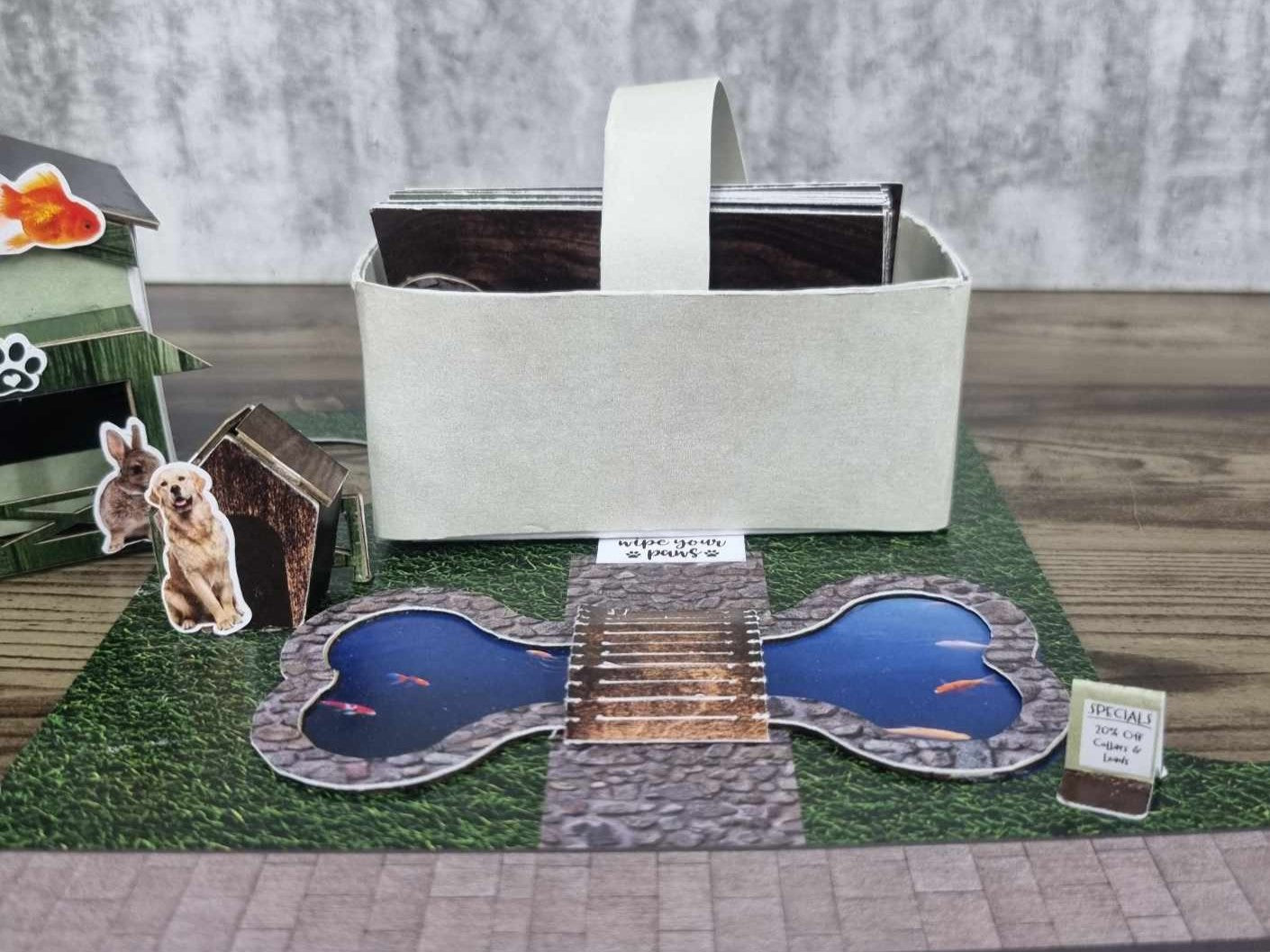 3Quarter Designs Pet Tails Pet Shop paper basket and bone-shaped pond pieces displayed in front of the assembled shop
