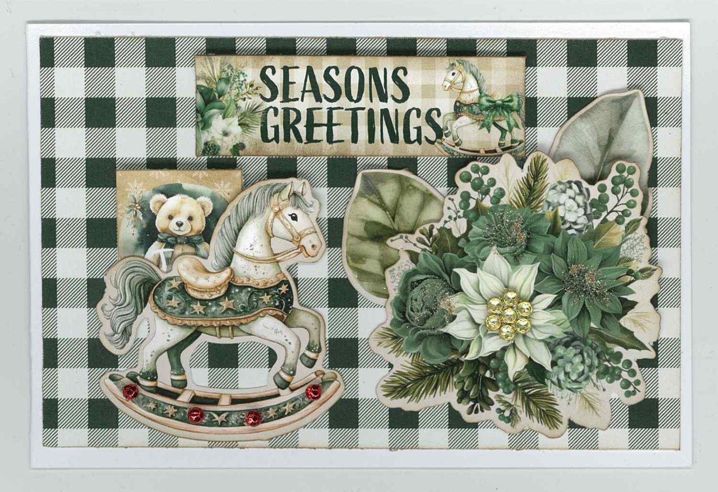 Pine Festivities card sample showing a landscape card with green and cream buffalo check background, die-cut rocking horse, teddy bear, poinsettia cluster and Seasons Greetings word strip