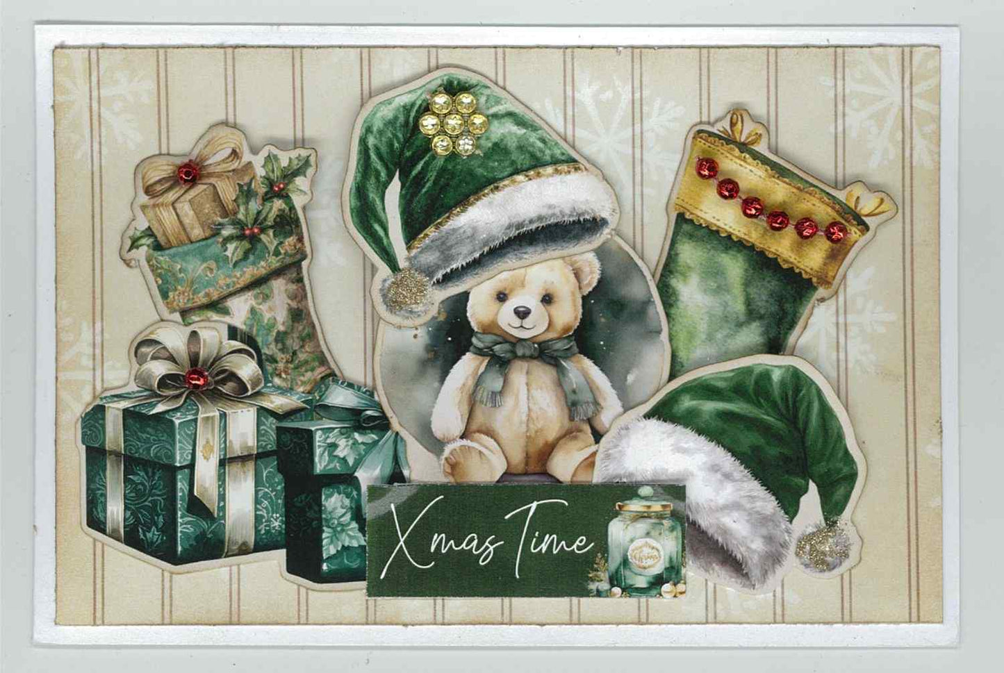  Pine Festivities card sample showing a landscape card with soft snowflake background, die-cut teddy bear in green Santa hat, Christmas stocking with red gem trim, gift boxes and Xmas Time word strip