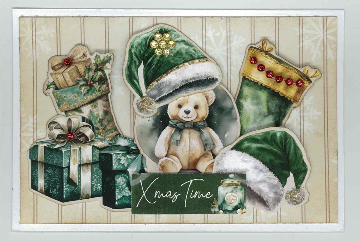  Pine Festivities card sample showing a landscape card with soft snowflake background, die-cut teddy bear in green Santa hat, Christmas stocking with red gem trim, gift boxes and Xmas Time word strip