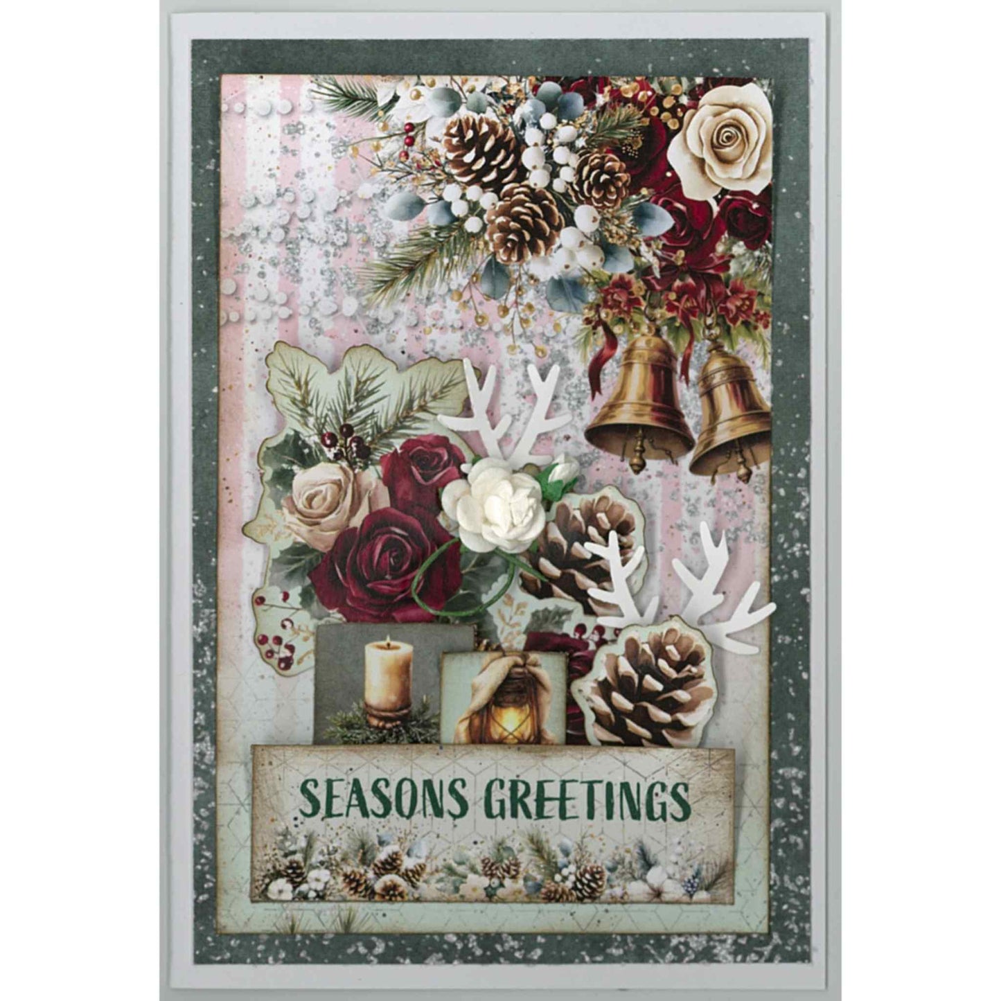 Handmade Silent Night Christmas card featuring gold bells, pine cones, cream and burgundy roses, white paper flower, candle, lantern, holly and Seasons Greetings sentiment on pink and teal textured background