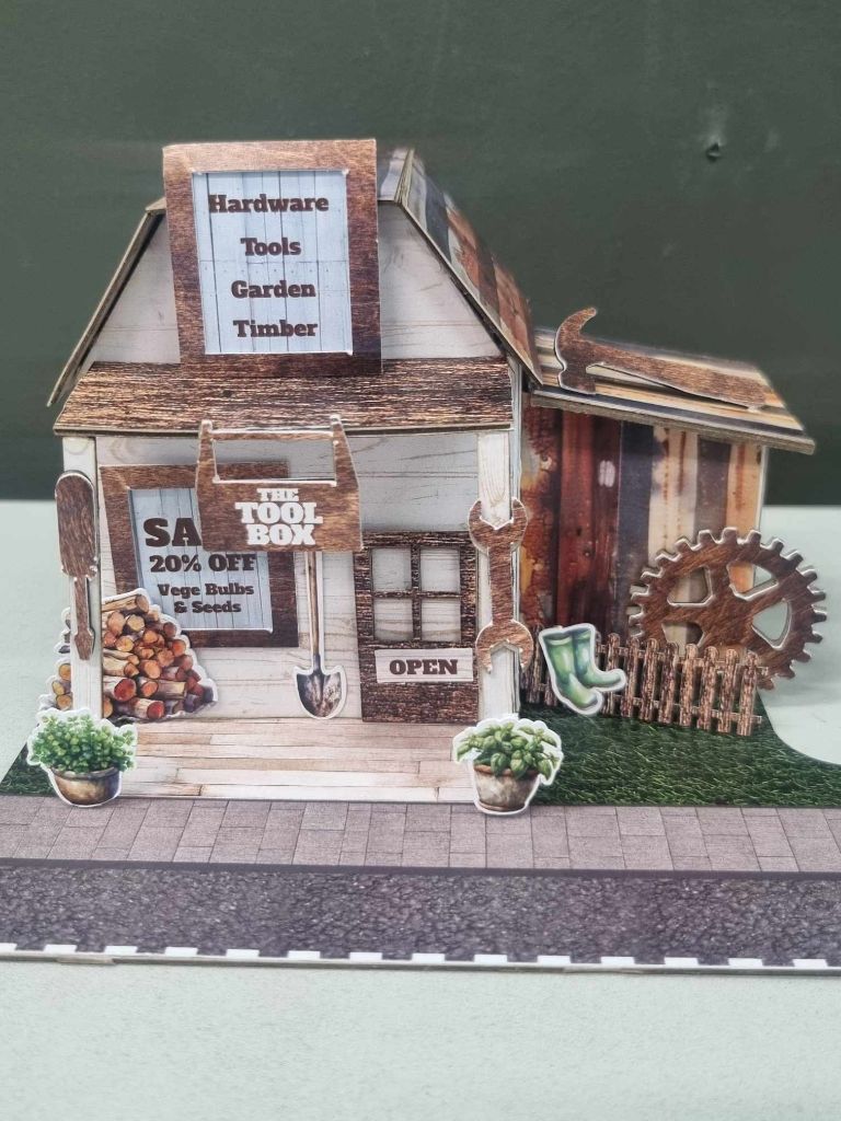 Assembled Toolbox miniature hardware store with weathered timber cladding, corrugated iron roof, and Hardware Tools Garden Timber dormer sign