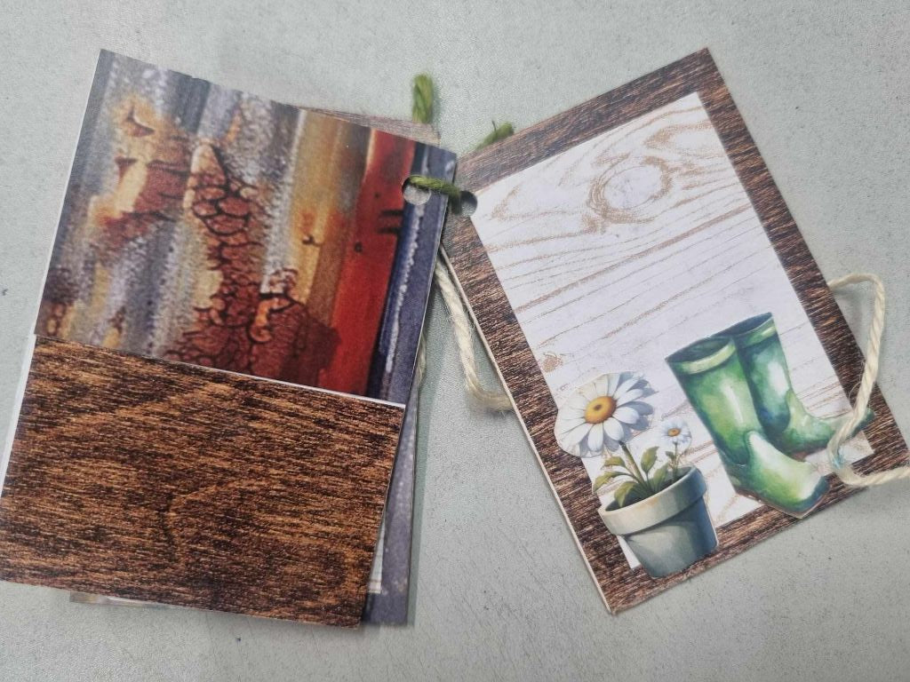Sample mini album for The Toolbox open to a spread showing rustic corrugated iron patterned paper alongside a gumboots and daisy illustration