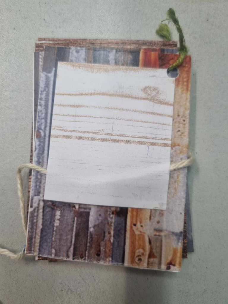 Sample mini album for The Toolbox closed from the back, showing the rustic corrugated iron and timber patterned paper covers