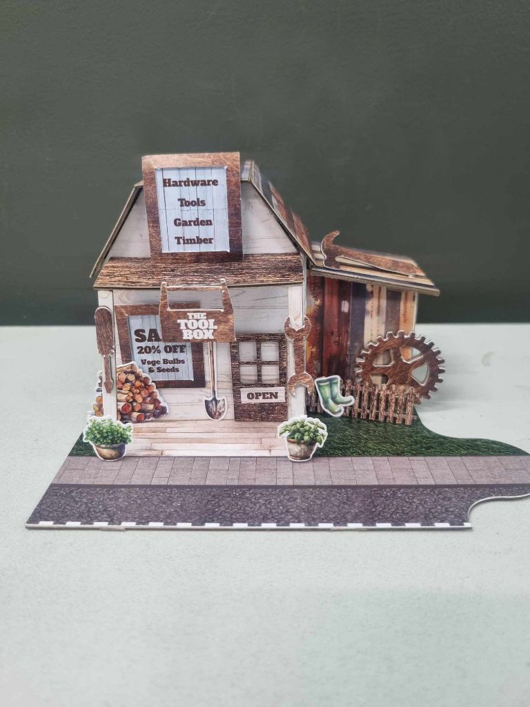 Three-quarter view of The Toolbox showing the full scene with firewood, potted plants, and rustic shed attachment