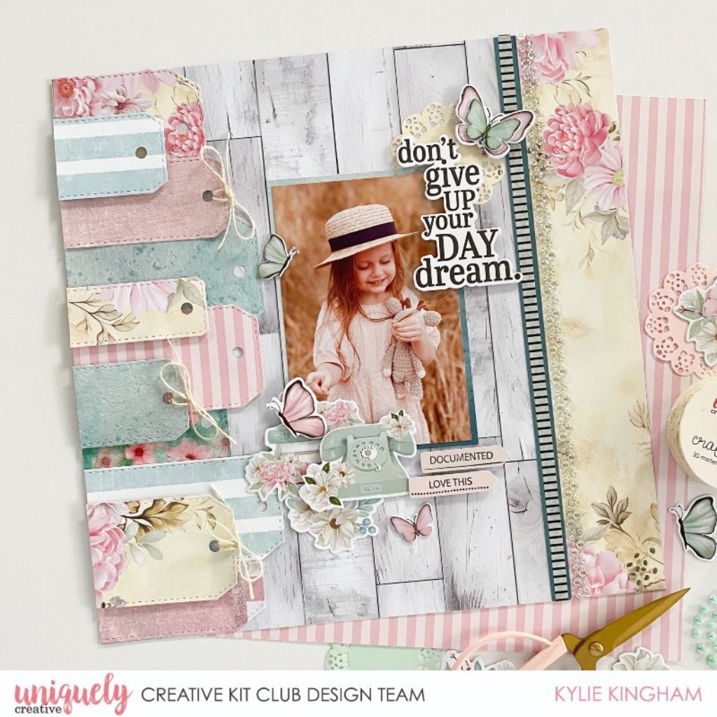 Pastel floral scrapbook layout with a child’s portrait, layered tags, butterflies and a pearl tape border