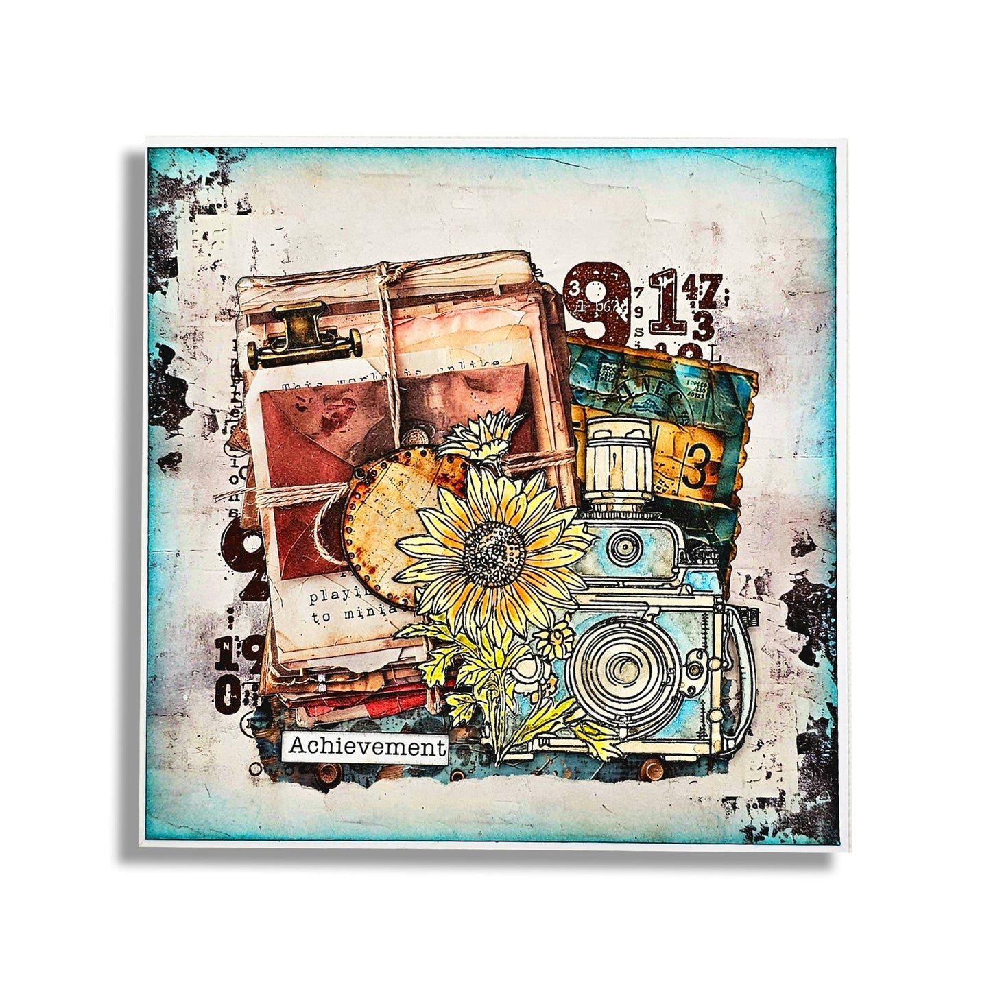 'Achievement' mixed media canvas made with AALL & Create Bronze & Brassy Days papers featuring stacked vintage books tied with twine, yellow sunflowers, vintage camera, ephemera tags with numbers, and distressed turquoise and cream background with black ink splatter