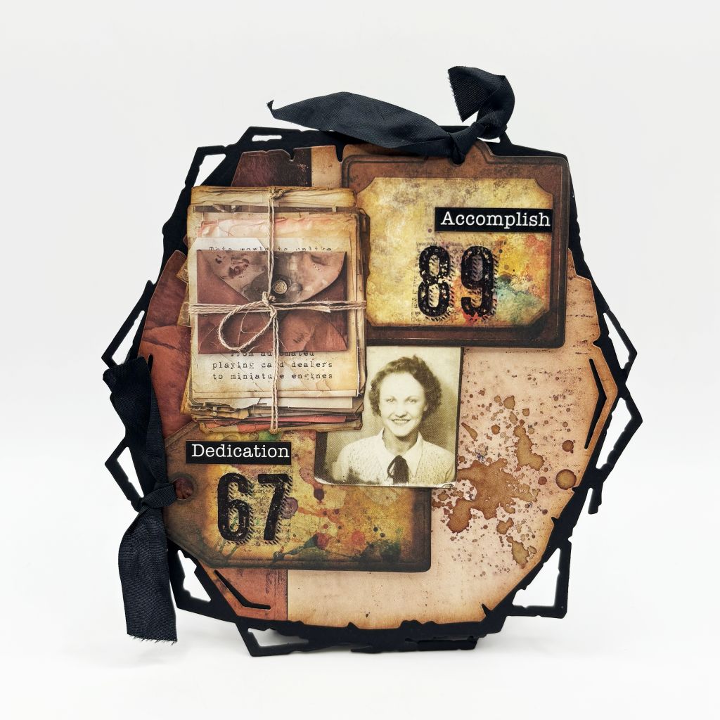 "Heritage hexagon piece made with AALL & Create Bronze & Brassy Days papers featuring vintage sepia photograph, stacked ephemera cards tied with twine, 'Accomplish 89' and 'Dedication 67' tags, distressed bronze and cream backgrounds with black geometric frame and ribbon