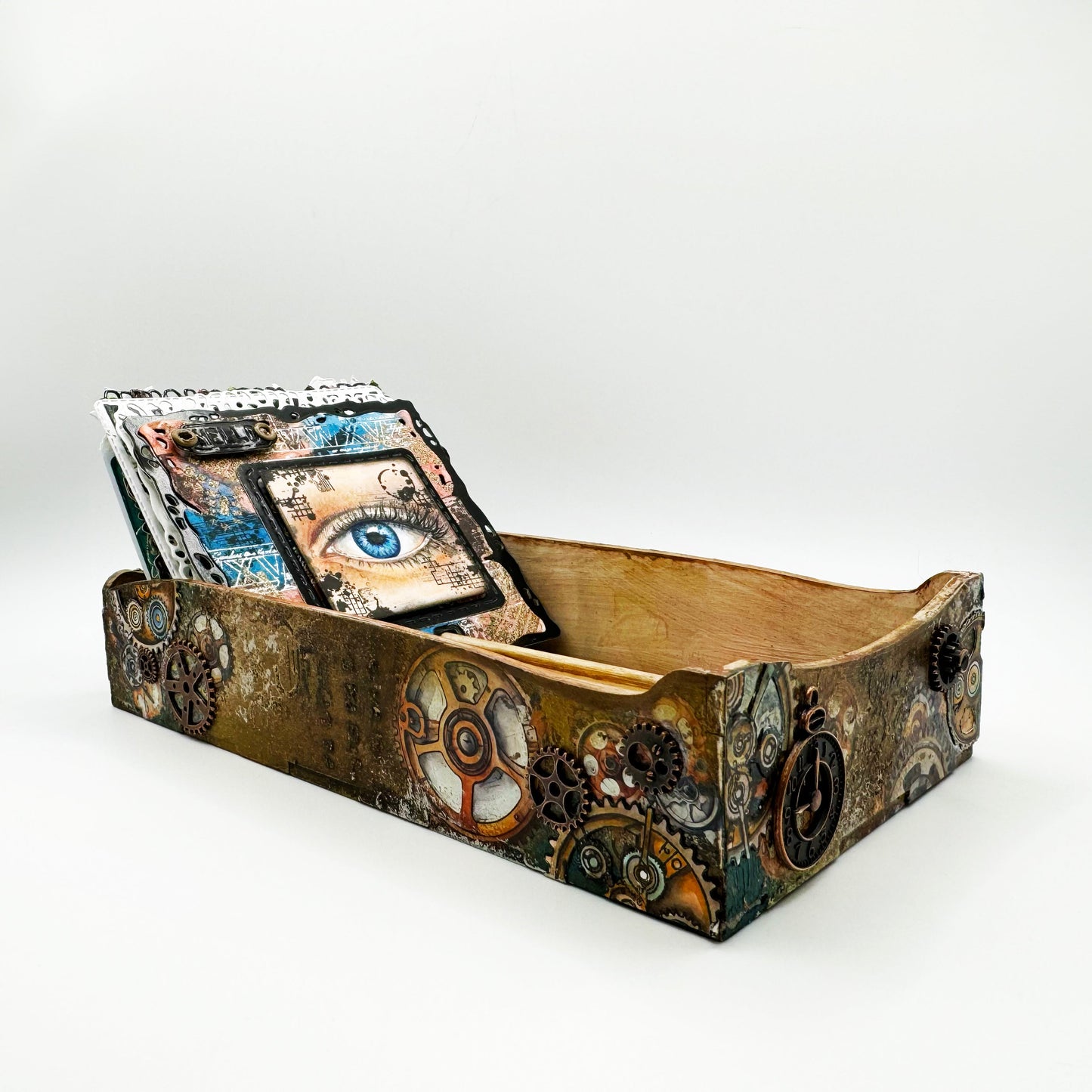 Steampunk decorative box made with AALL & Create Cogs & Curios rub-ons featuring bronze and turquoise gears on aged gold metallic finish with eye imagery and vintage ephemera on index cards