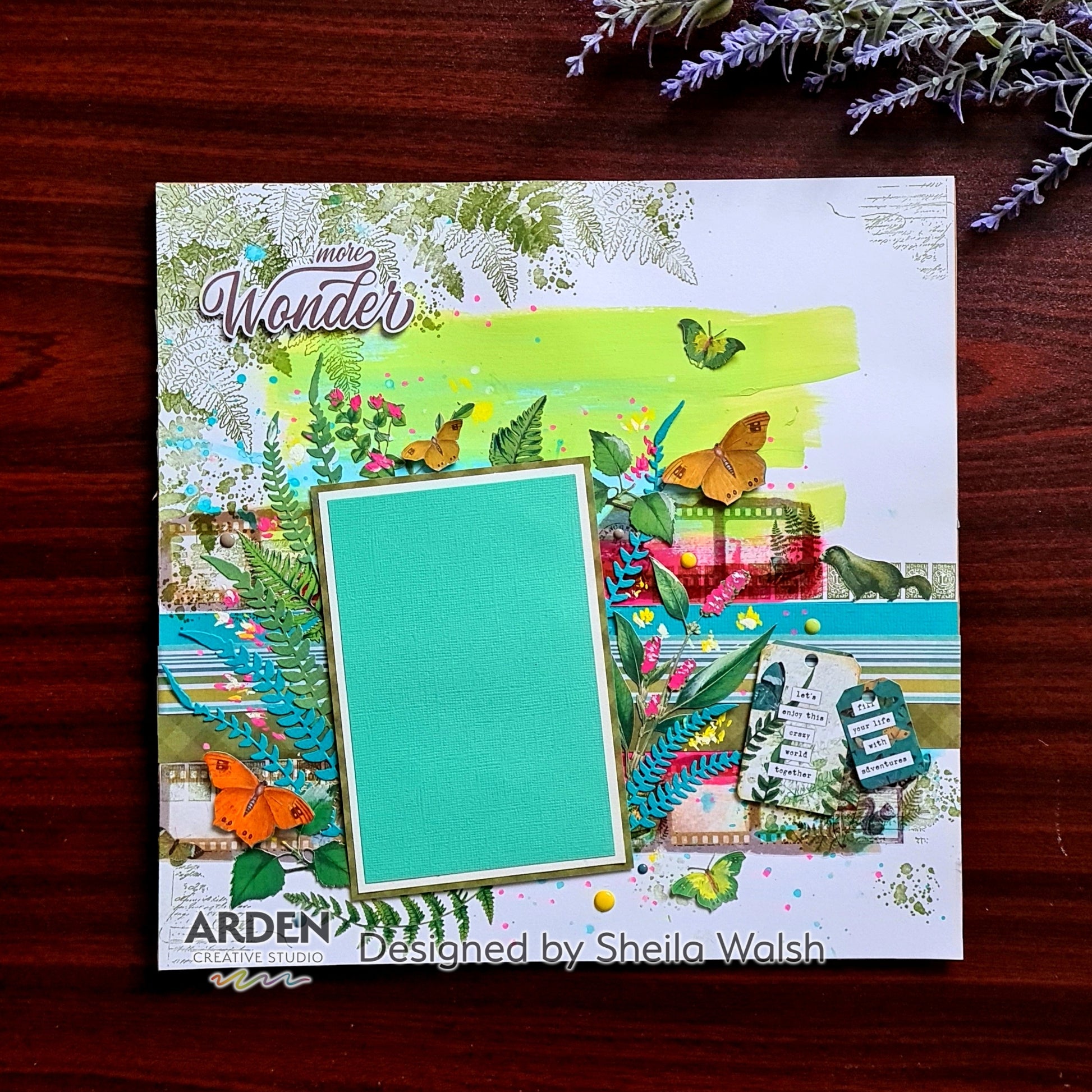 Scrapbook layout sample using Arden Creative Studio Hidden Creek collection, featuring butterfly die-cuts, fern stamping, vibrant green and teal cardstock, mixed media ink splatters, and layered patterned papers.