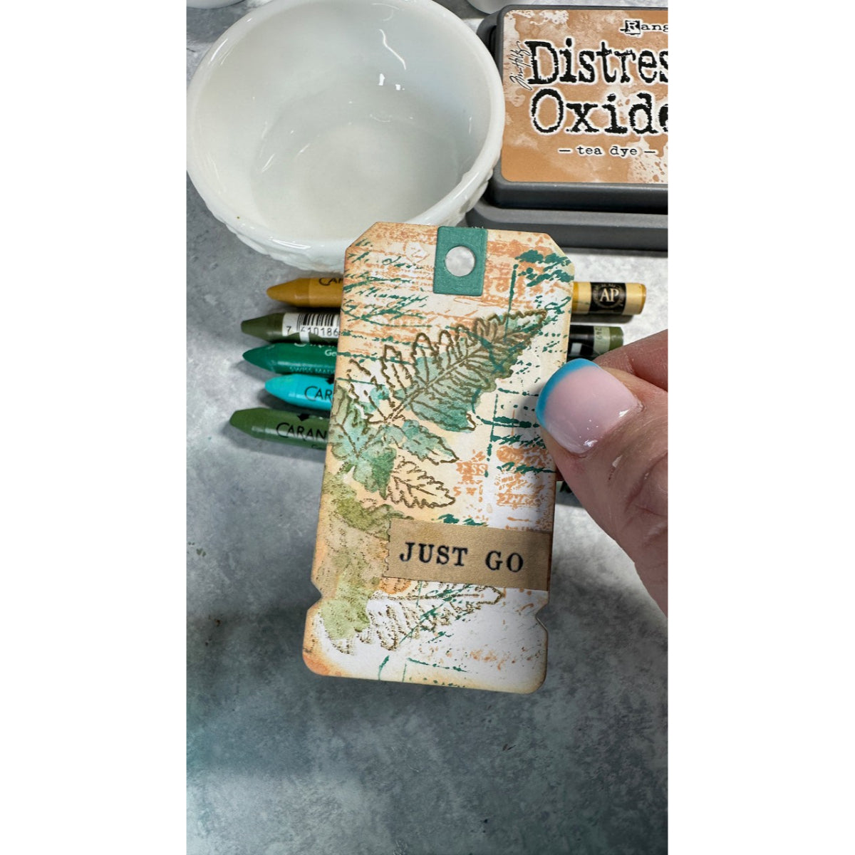 Handmade tag sample using Arden Creative Studio Hidden Creek collection, featuring botanical leaf stamping in green and gold tones, Distress Oxide ink blending in tea dye, and a "Just Go" kraft sentiment banner.