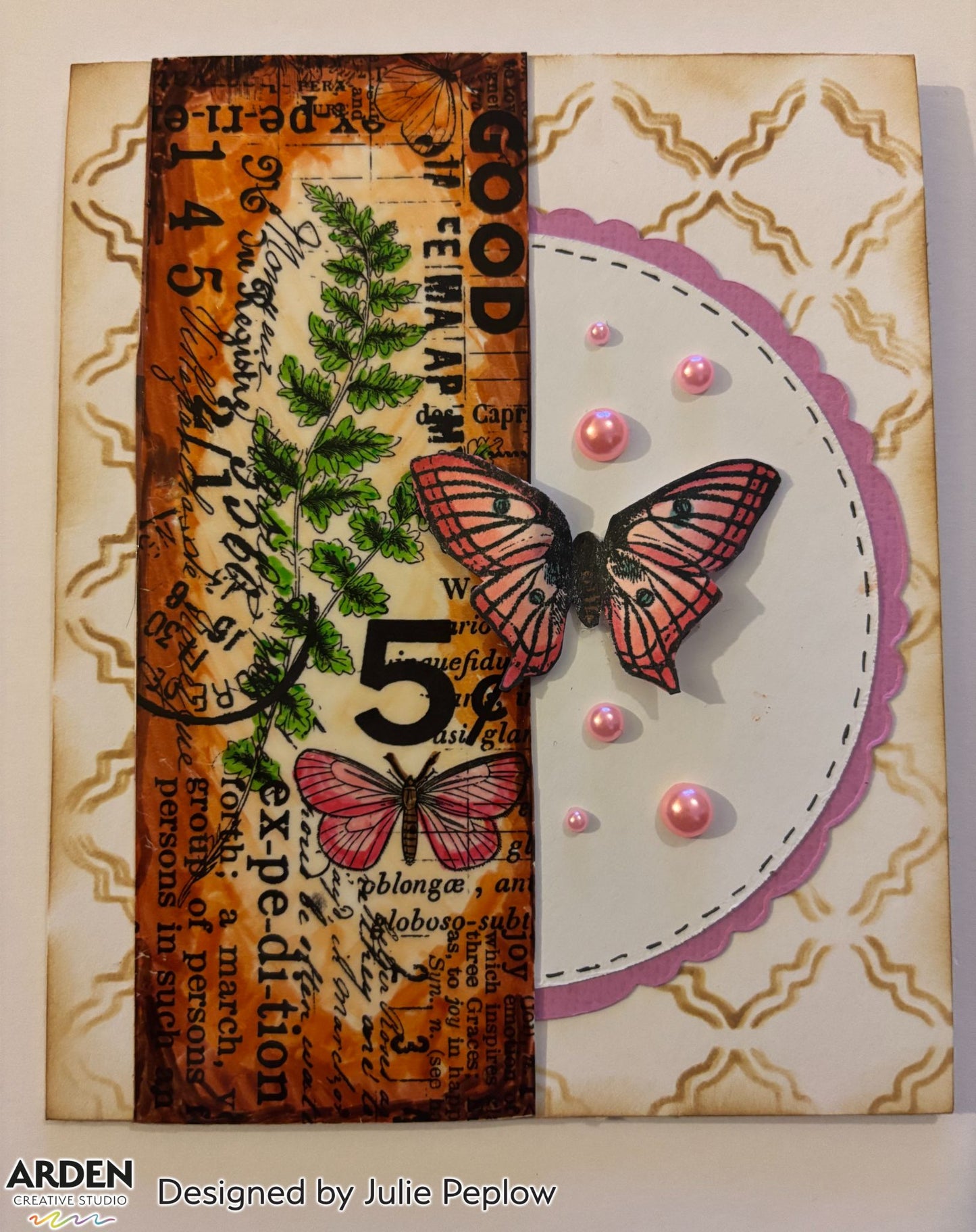 Handmade card sample using Arden Creative Studio Hidden Creek collection, featuring warm orange Distress Oxide ink blending, fern stamping, pink butterfly stamp and die-cut focal point, vintage script and typography background stamping, scalloped purple circle panel, and pink pearl embellishments.