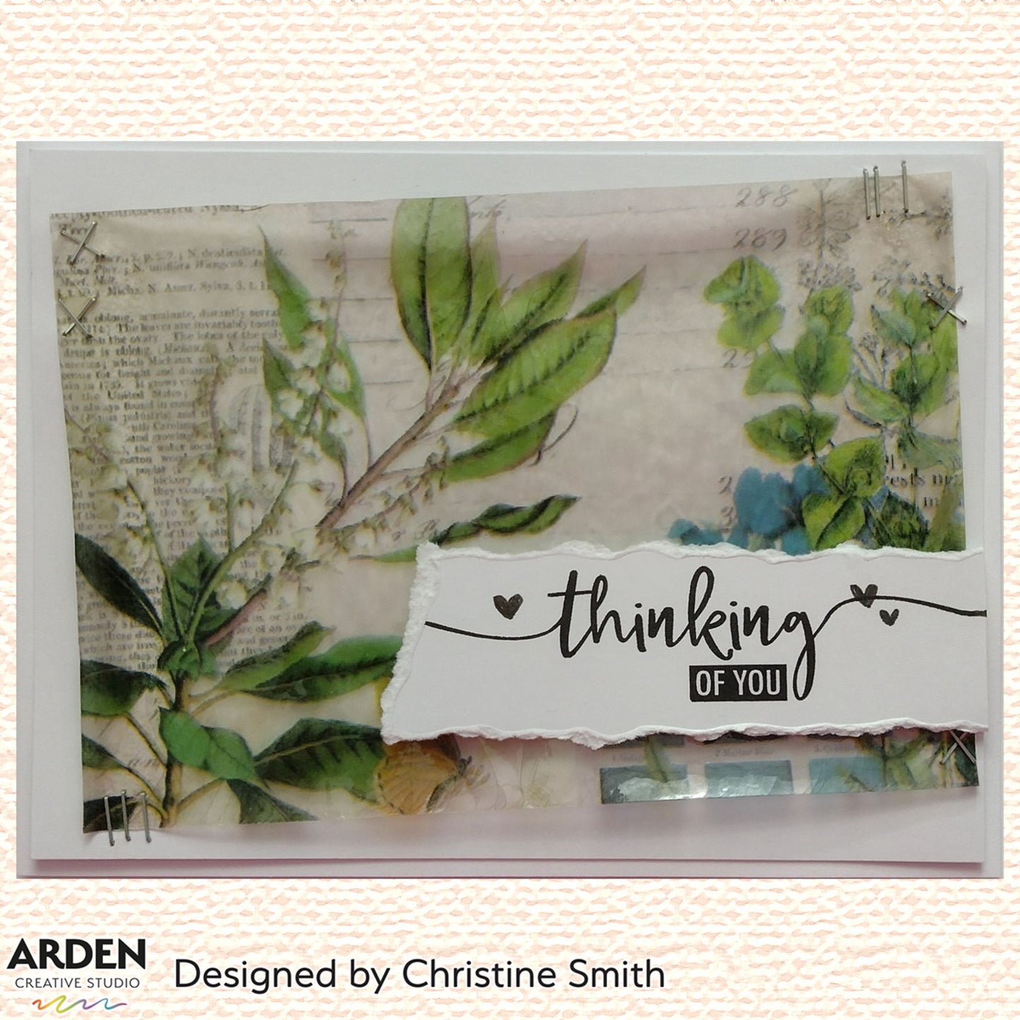 Handmade "Thinking of You" card sample using Arden Creative Studio Hidden Creek collection, featuring botanical patterned paper with green leaf and lily of the valley imagery, vintage script background, torn paper panel, silver staple embellishments, and a hand-lettered sentiment stamp.