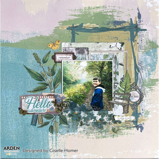 "Hello Adventure" scrapbook layout sample using Arden Creative Studio Hidden Creek collection, featuring a nature walk photo, botanical leaf and fern die-cuts, film strip sentiment, and a mixed media teal and sage brush stroke background.