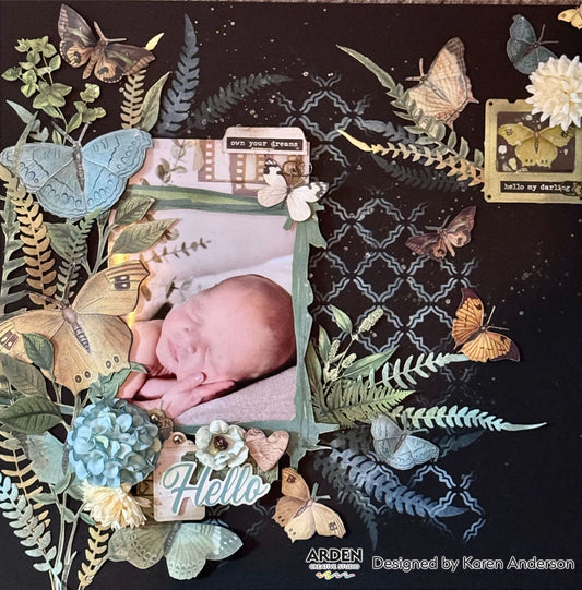 "Hello My Darling" newborn scrapbook layout sample using Arden Creative Studio Hidden Creek collection, featuring a baby photo, multiple butterfly and fern die-cuts, blue hydrangea flowers, and a dark navy Moroccan stencilled background with gold ink detailing.