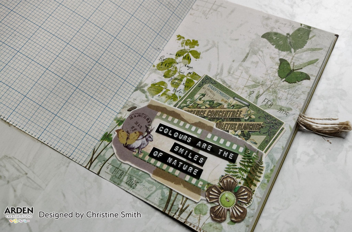"Colours Are the Smiles of Nature" junk journal page sample using Arden Creative Studio Hidden Creek collection, featuring botanical patterned paper, vintage French ephemera, film strip die-cut, squirrel die-cut, and a bronze flower embellishment on a green grid background.