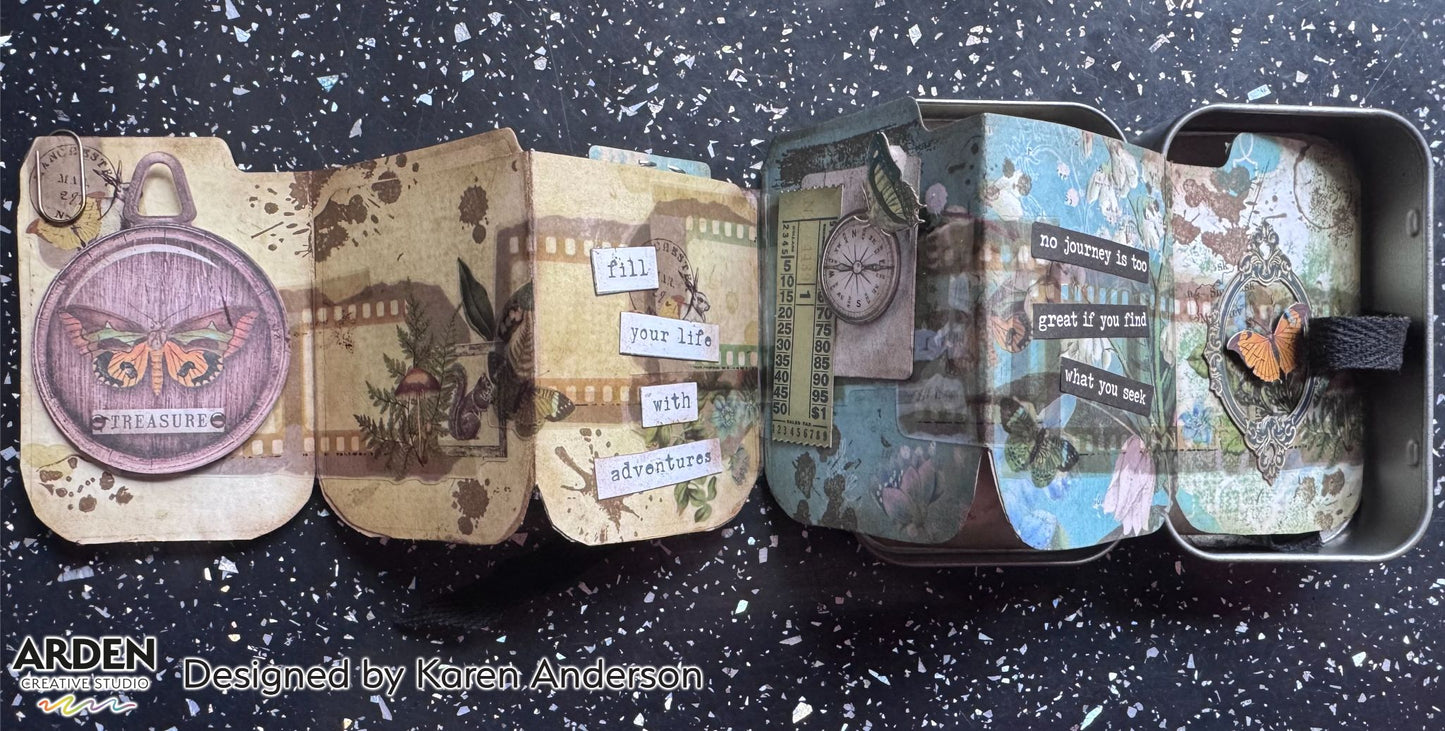 "Treasure / Fill Your Life With Adventures" altered tin accordion mini album sample using Arden Creative Studio Hidden Creek collection, featuring a pocket watch die-cut, film strip panels, compass and ledger patterned papers, butterfly embellishment, and vintage typography ephemera.
