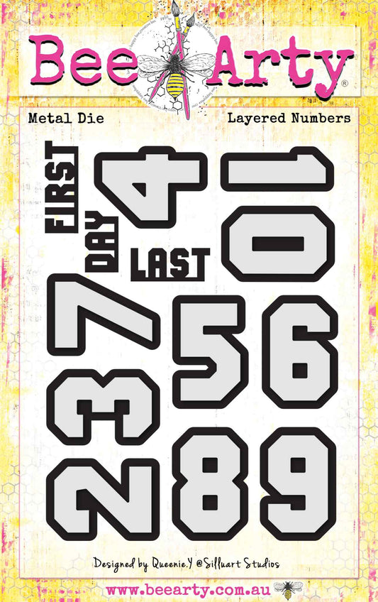 Bee Arty Layered Numbers Die Set designed by Queenie Y, featuring bold varsity-style layered dies for digits 0 to 9 each approx 4cm high with number and shadow die per digit, plus word dies for FIRST, DAY and LAST, 23 dies total
