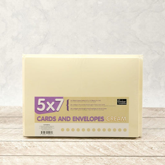 Packet of 5x7" cream cards and envelopes on a wooden surface with a light grey background