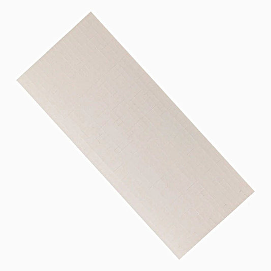 Sheet of white adhesive foam squares on a white background. 