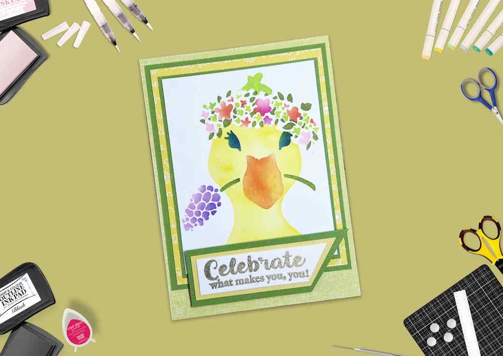 Handmade green card featuring a colourful floral duck design with the Celebrate what makes you, you! sentiment